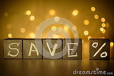 Save % chalk written on black cubes on blurred bokeh background Stock Photo