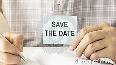 SAVE THE DATE message on the card shown by a man Stock Photo