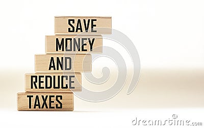 SAVE MONEY AND REDUCE TAXES text on wooden blocks and white background. Stock Photo