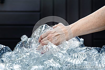 Save our environment. Female hands grabbing plastic bottles Stock Photo