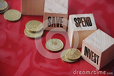 Save spend invest on Wooden Cubes and coins on red backgroud. Financial concept Stock Photo