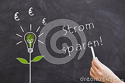 Saving electricity word on a blackboard in german Stock Photo