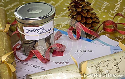 Saving jar containing coins with Christmas Saving label on overdue and final demand household bills Stock Photo