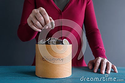 Saving Money for Emergency Concept. Woman putting Coin into a Bo Stock Photo