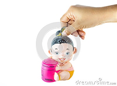 Saving money into Thai style's doll as piggy-bank Stock Photo