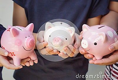 Three kids holding piggy banks Stock Photo