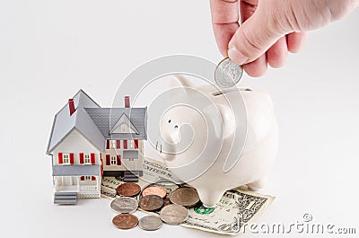 Saving to build / buy a home / house. Piggy bank with coin being Stock Photo