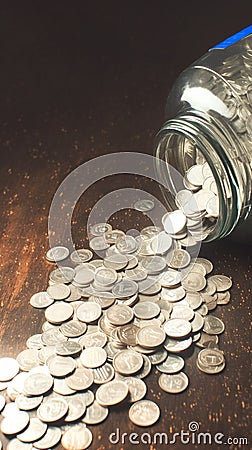 Savings overflow Coins with a car label spill on table Stock Photo