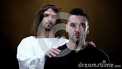Savior supporting crying man in trouble, spiritual redemption, divine will Stock Photo