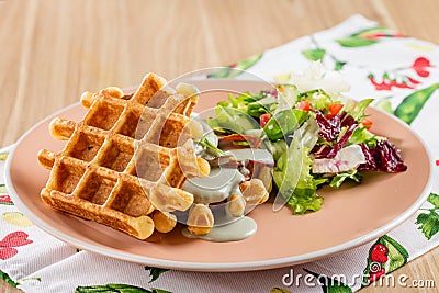 Savory Belgian waffles with cheese sauce and salad Stock Photo