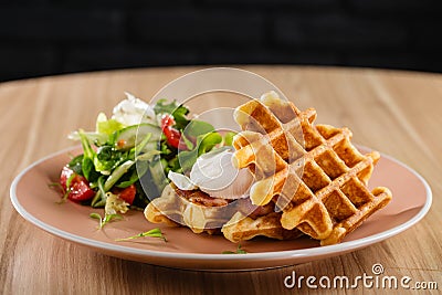 Savory Belgian waffles with egg poached, bacon and salad Stock Photo