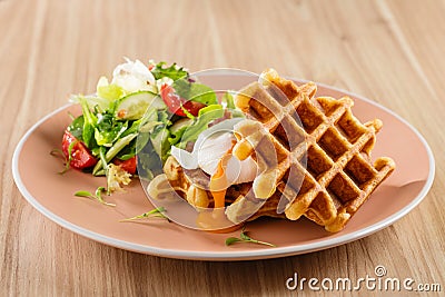 Savory Belgian waffles with egg poached, bacon and salad Stock Photo