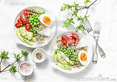 Savory breakfast grain bowl. Balanced buddha bowl with quinoa, egg, avocado, tomato, green pea on light background. Healthy diet Stock Photo