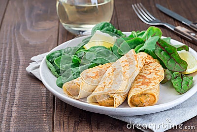 Savory crepe with shrimps and creamy dill sauce served with green leaves salad and lemon, horizontal, copy space Stock Photo