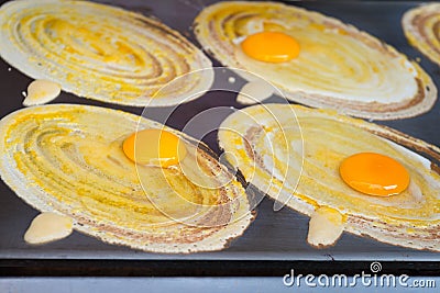 Savory Crepes Cooking on a Street Food Vendor's Griddle in Bangk Stock Photo