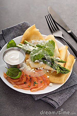 Savory crepes with salmon, sour cream and asparagus Stock Photo