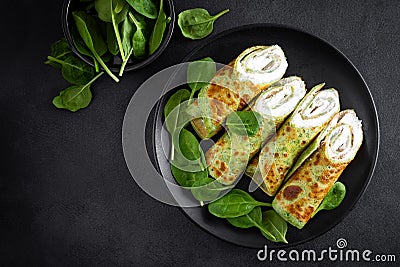 Savory crepes with spinach and feta cheese on black background, top view Stock Photo