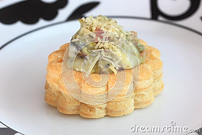 Savory filled pastry case or vol-au-vent on dinner plate Stock Photo