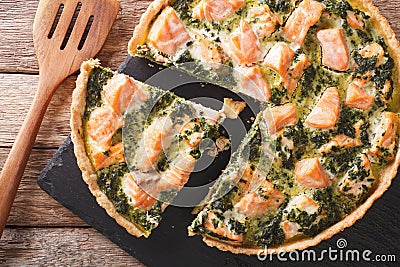 Savory food: sliced tart with salmon, spinach and cream close-up. Horizontal top view Stock Photo