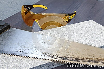 A saw on a tree lies on a wooden board next to it Stock Photo