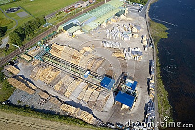 Sawmill aerial view chopped tree wood logs stacks in a row with machinery Stock Photo