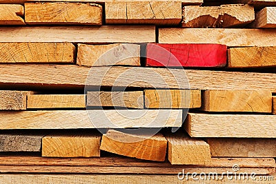 Sawn and folded boards with an emphasis on one red board, construction boards, full-screen lumber as a background Stock Photo