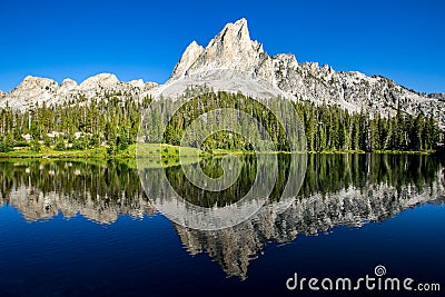 Sawtooth mountains reflected in Alice Lake, Idaho Stock Photo