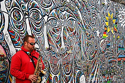 Saxofonist by the wall Editorial Stock Photo