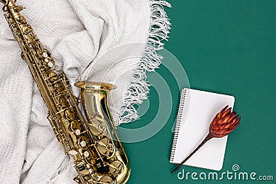 Saxophone on a green background and notepad, top view. Stock Photo