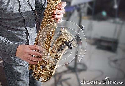 Saxophone playing. Hands of a man playing the saxophone. Dark background. Copy space Stock Photo