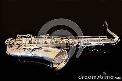 Saxophone tenor. Woodwind Classical Instrument. Jazz, blues, classics. Music. Saxophone on a black background. Black mirror surfac Stock Photo