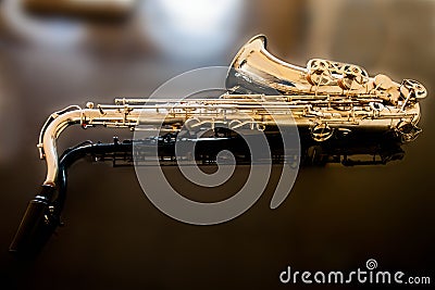 Saxophone tenor. Woodwind Classical Instrument. Jazz, blues, classics. Music. Saxophone on a black background. Black mirror surfac Stock Photo