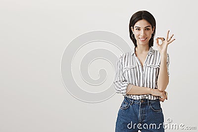 Say yes to new opportunities. Studio shot of beautiful dark-haired caucasian woman in stylish clothes showing okay or Stock Photo