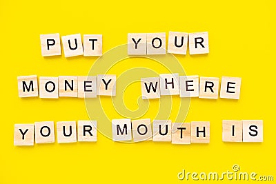 Sayings Put your money where your mouth is on yellow background. Stock Photo