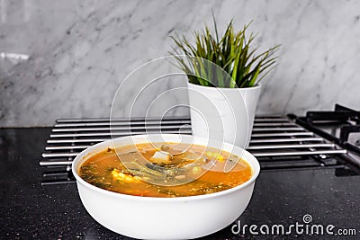 Sayur asem is a popular Indonesian vegetable in tamarind soupâ€Ž with jack fruit, corn, long beans in a white bowl in a kitchen. Stock Photo