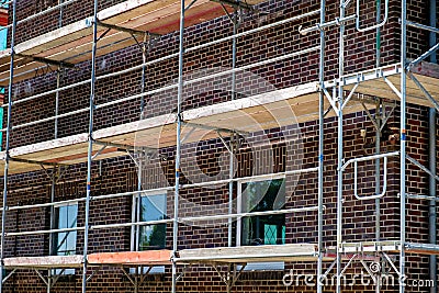 Scaffolding near a high-rise brick house under construction in Germany. Stock Photo