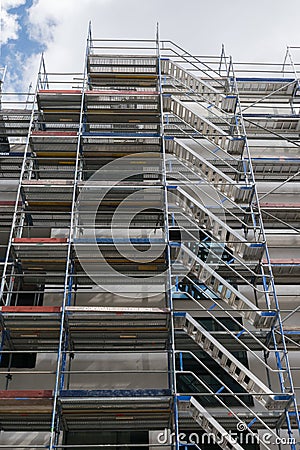 Scaffolding near a new house, building exterior, construction and repair industry, white wall and window Stock Photo