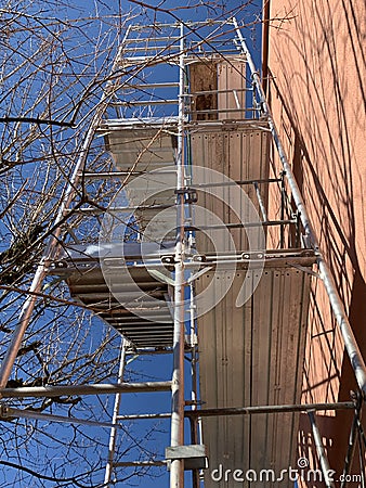 Scaffolding on a residential building with branches of trees touching it Stock Photo