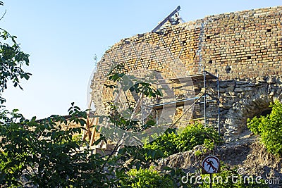 Scaffolding and winch during the restoration of the wall of a medieval castle Stock Photo