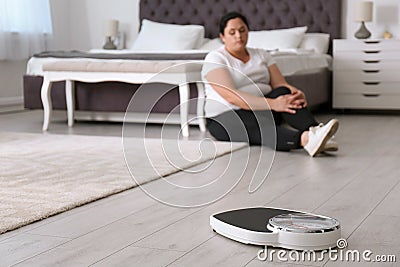 Scales and overweight woman in sportswea Stock Photo