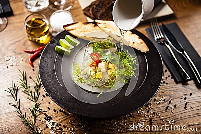 Scallop ceviche served in black bowl with liquid ice smoke Stock Photo