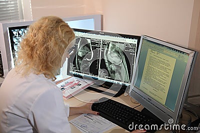 Scan medical test /examination in a modern hospital. MRI machine and screens with doctor. Editorial Stock Photo