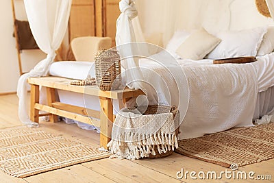 Scandinavian bedroom interior decoration with comfortable bed and pillows. Cozy room with decoration and wisker basket with plaids Stock Photo