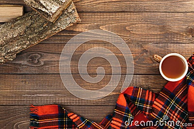 Scandinavian hygge style autumn flatlay composition. Frame of fashion feminine red scarf, cup of tea, firewood on wooden Stock Photo