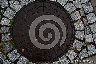 Scandinavian manhole in its urban surrounding. Stock Photo