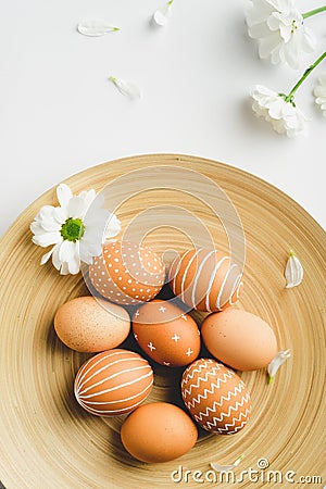 Scandinavian style easter eggs in plate and spring flowers on white background. Flat lay composition, top view. Simple, nordic Stock Photo