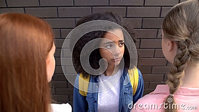 Scared afro-american schoolgirl looking elder students, bullying abuse, conflict Stock Photo