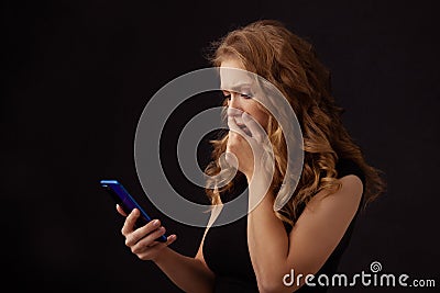 Scared annoyed girl watching phone and closing her mouth. Stock Photo