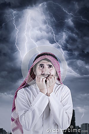 Scared Arabian person with thunderstorm Stock Photo