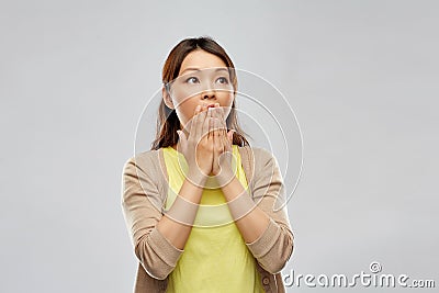 Scared asian woman over grey background Stock Photo
